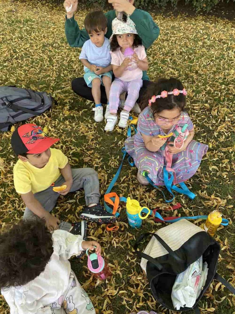 Children enjoying outdoor snack time during a Montessori activity at Rose Child Care Center in North Vancouver
